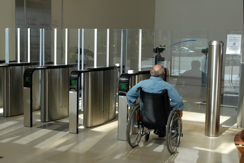 Image of a person in a wheelchair in front of a swing gate