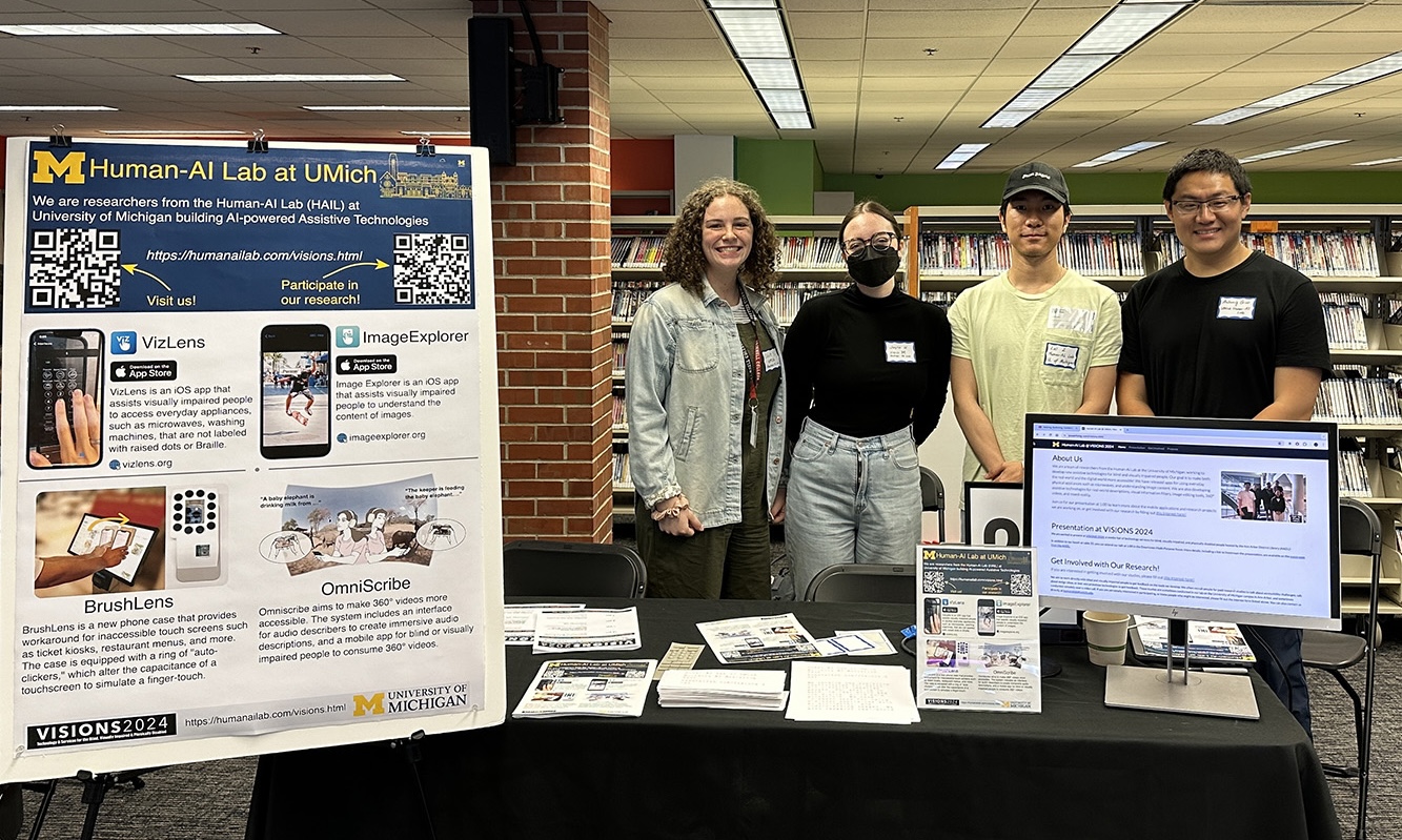 Human-AI Lab members standing in front of our booth at the VISIONS 2024 event hosted by the Ann Arbor District Library (AADL).