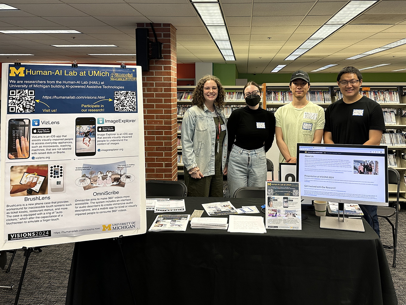 Human-AI Lab members standing in front of our booth.