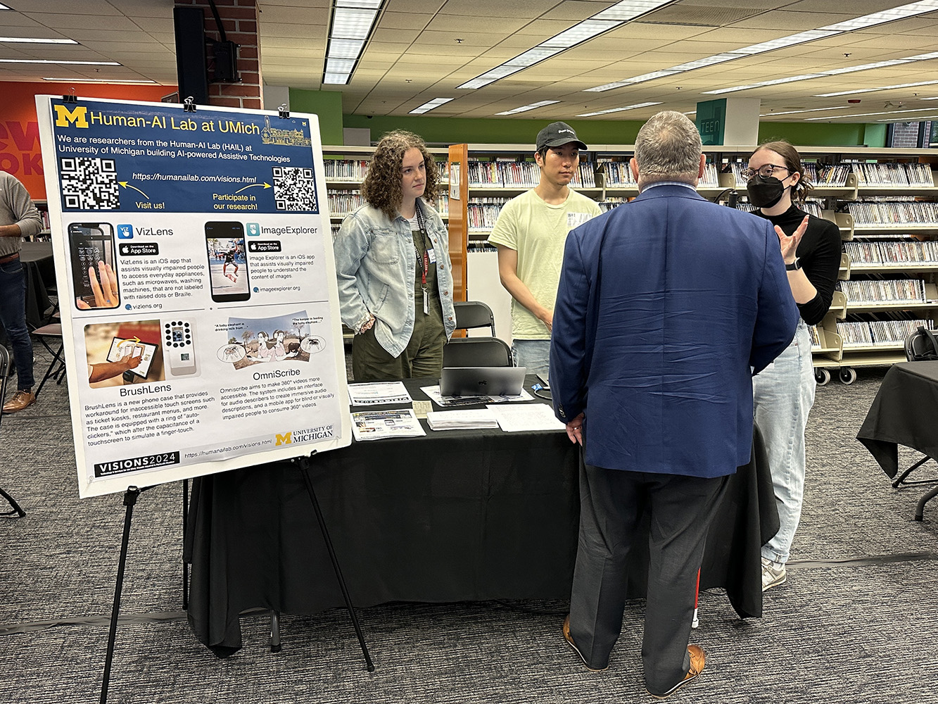 Human-AI Lab members talking to visitors at our booth.