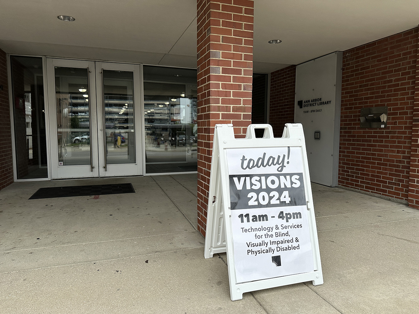 a sign says 'today! VISIONS 2024' at the Ann Arbor District Library